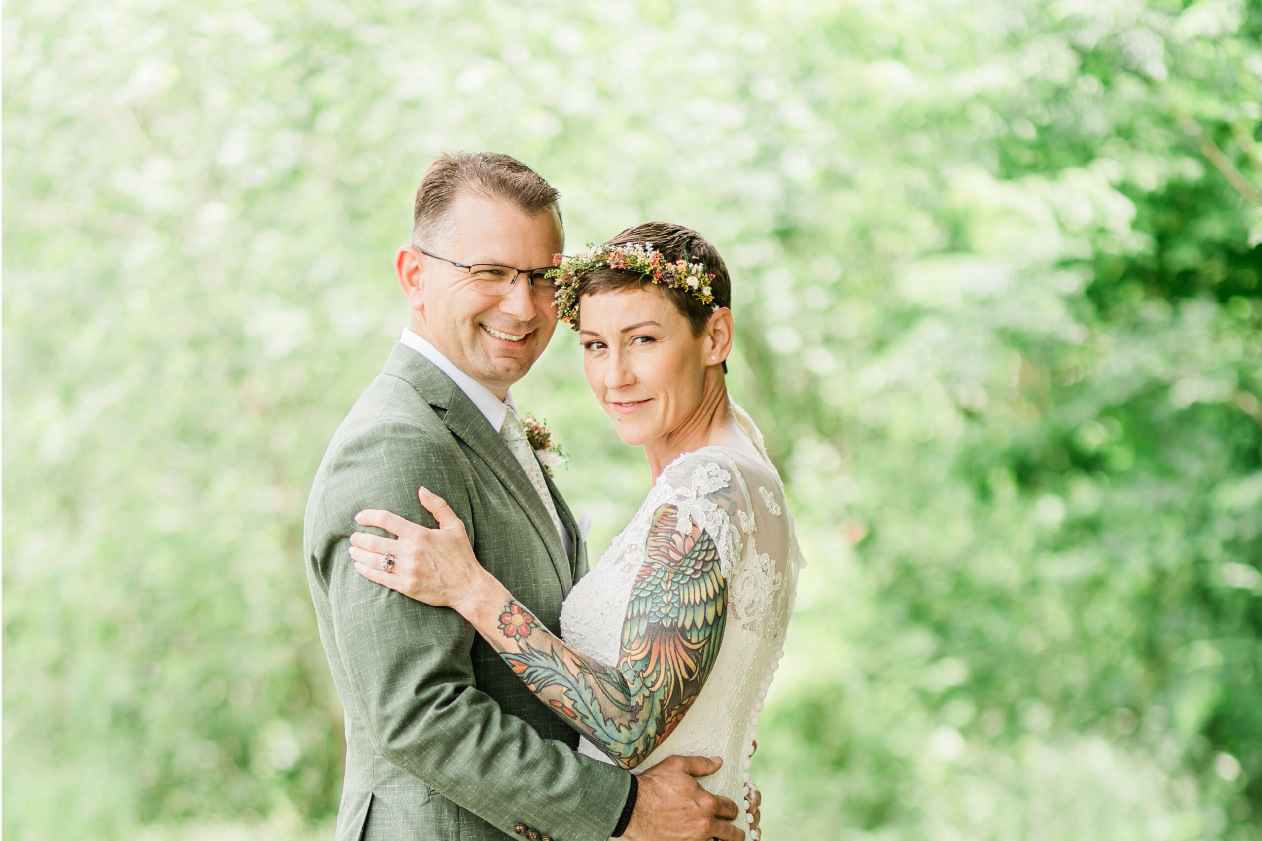 Bride and groom portrait in a lush green forest background.